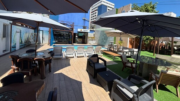 A patio area with outdoor seating, a pool, and a bar.