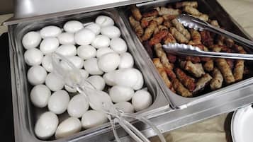 A buffet with two trays, one containing boiled eggs and the other containing sausages.
