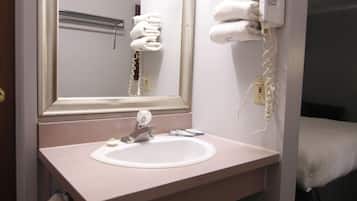 A bathroom with a sink, mirror, towel rack, and hairdryer.