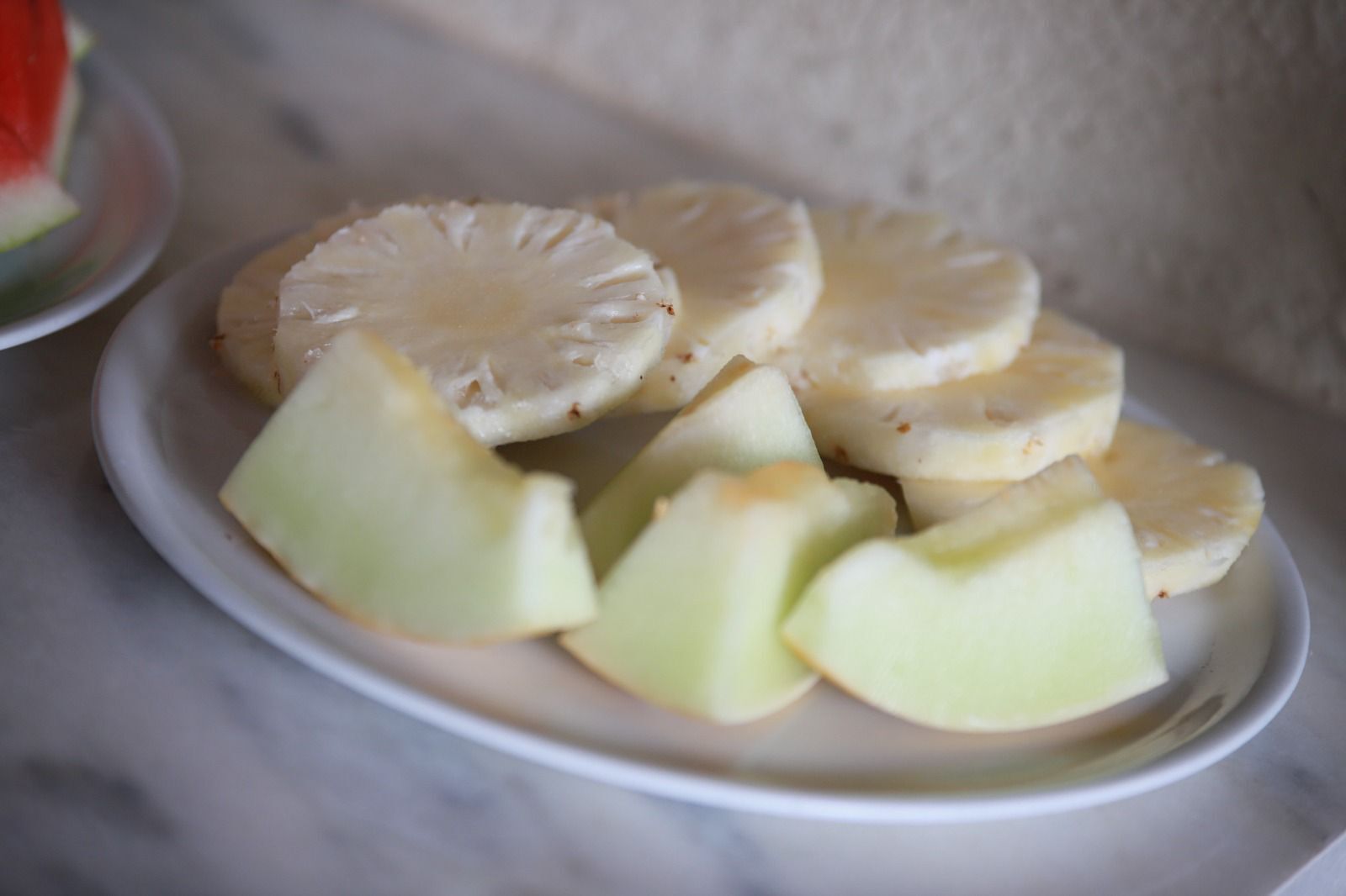 A plate with pineapple slices and apple wedges.