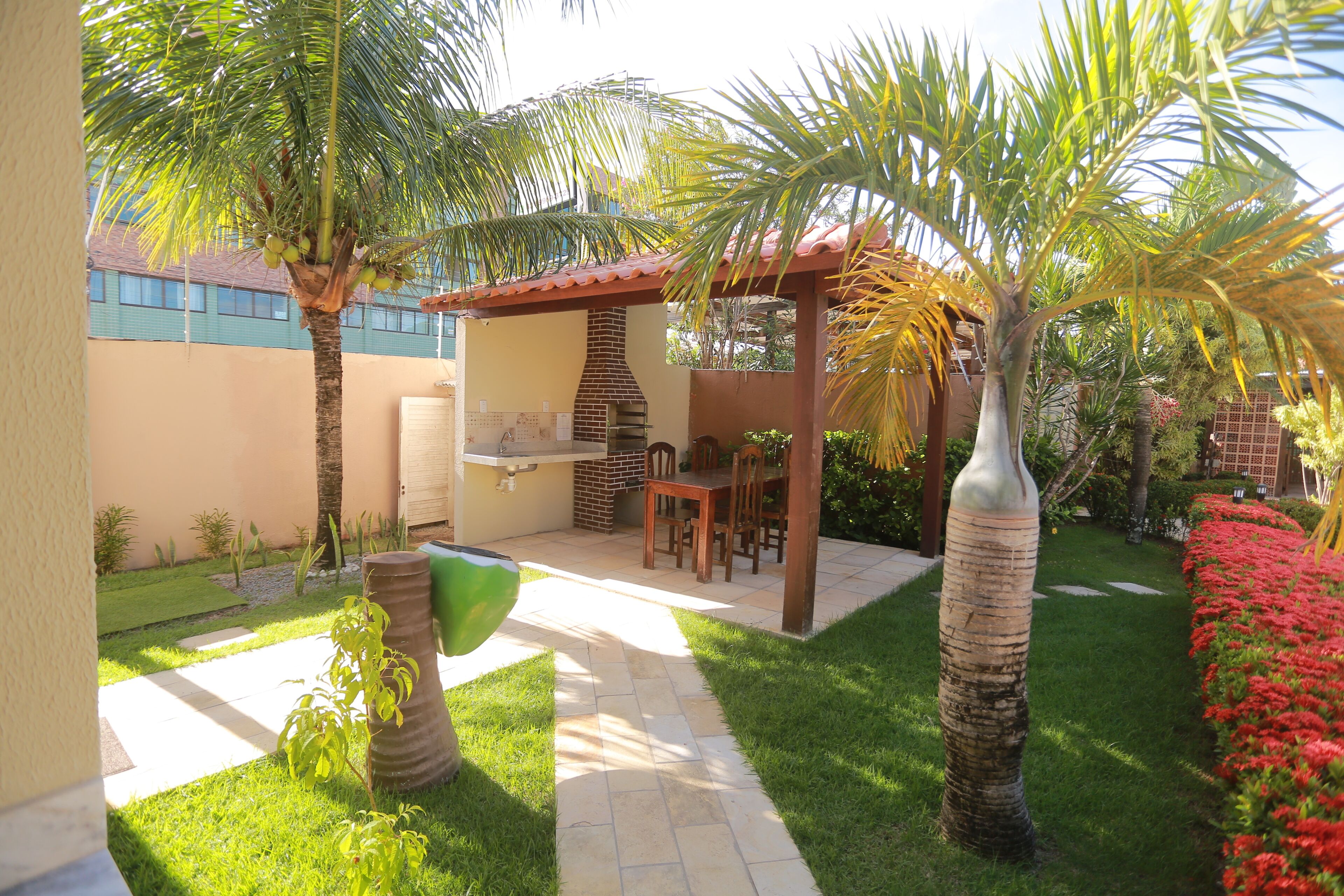 A patio with a grill, seating, and a pergola.
