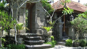 A traditional stone building with a tiled roof, surrounded by potted plants and a stone pathway. - Dewa Bharata Bungalow Ubud (Ubud)