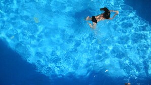 Una persona nadando en una piscina.