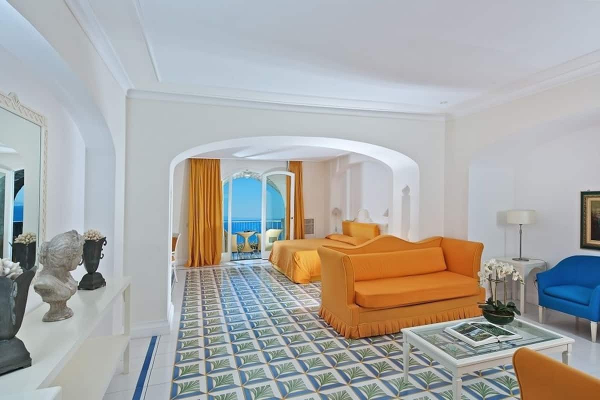 Ein Hotelzimmer mit einem gestreiften Boden, einem Sofa, einem Sessel und einem Bett.