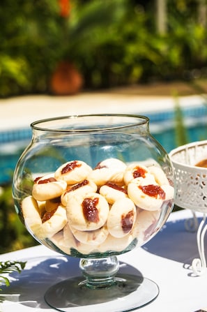A glass bowl filled with pastries on a table outdoors.
