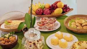 A table with various food items and a purple orchid.