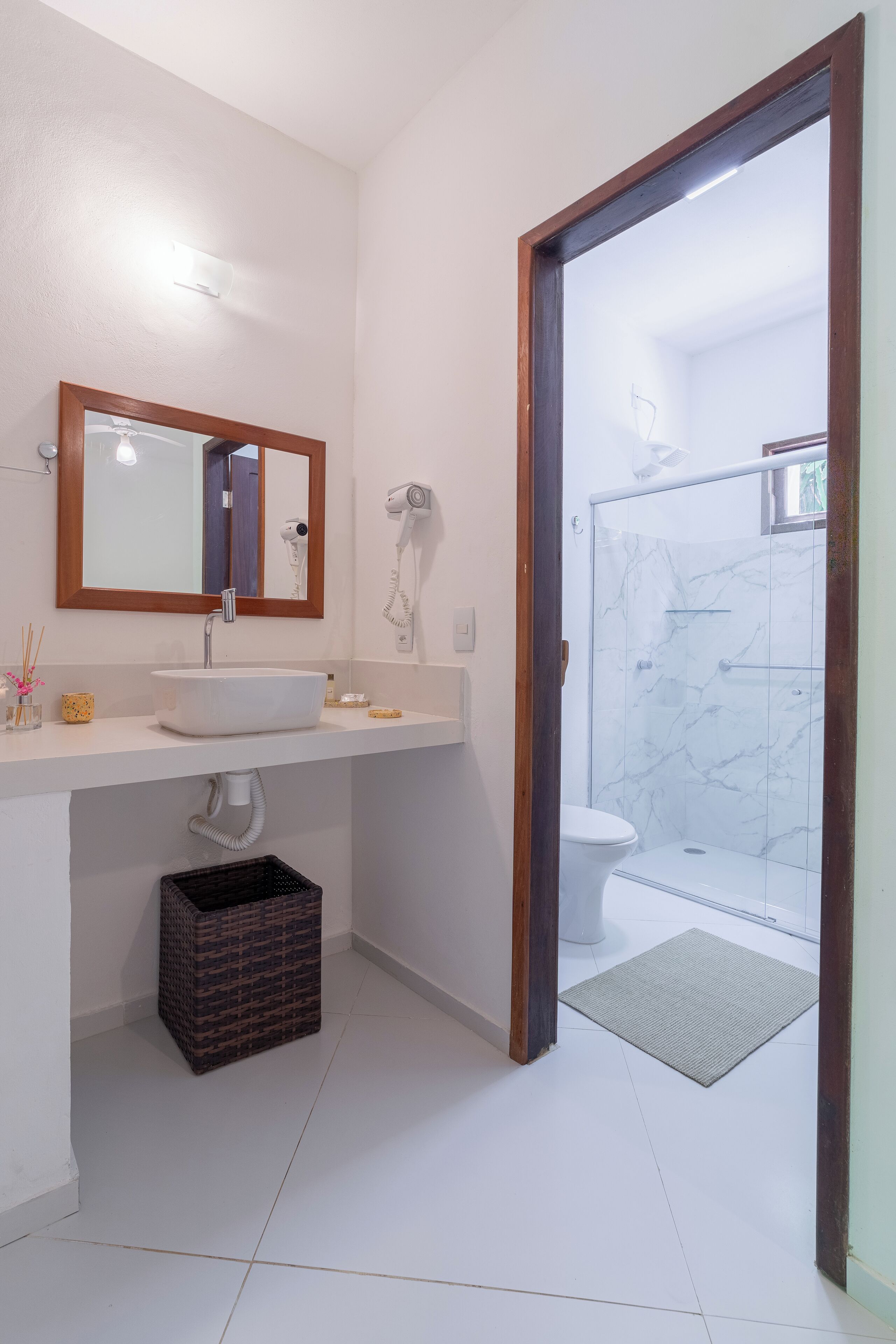 A bathroom with a white sink, mirror, and a shower area with a glass door.