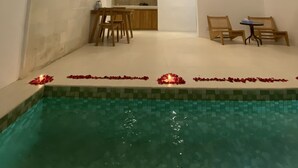 A modern interior with a pool, a dining area, and a kitchen. - Noah Villa and Chapel (Ungasan)