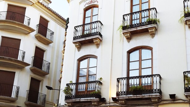 A building with multiple balconies, a café bar, and a restaurant. - Hotel Castilla (Antequera)