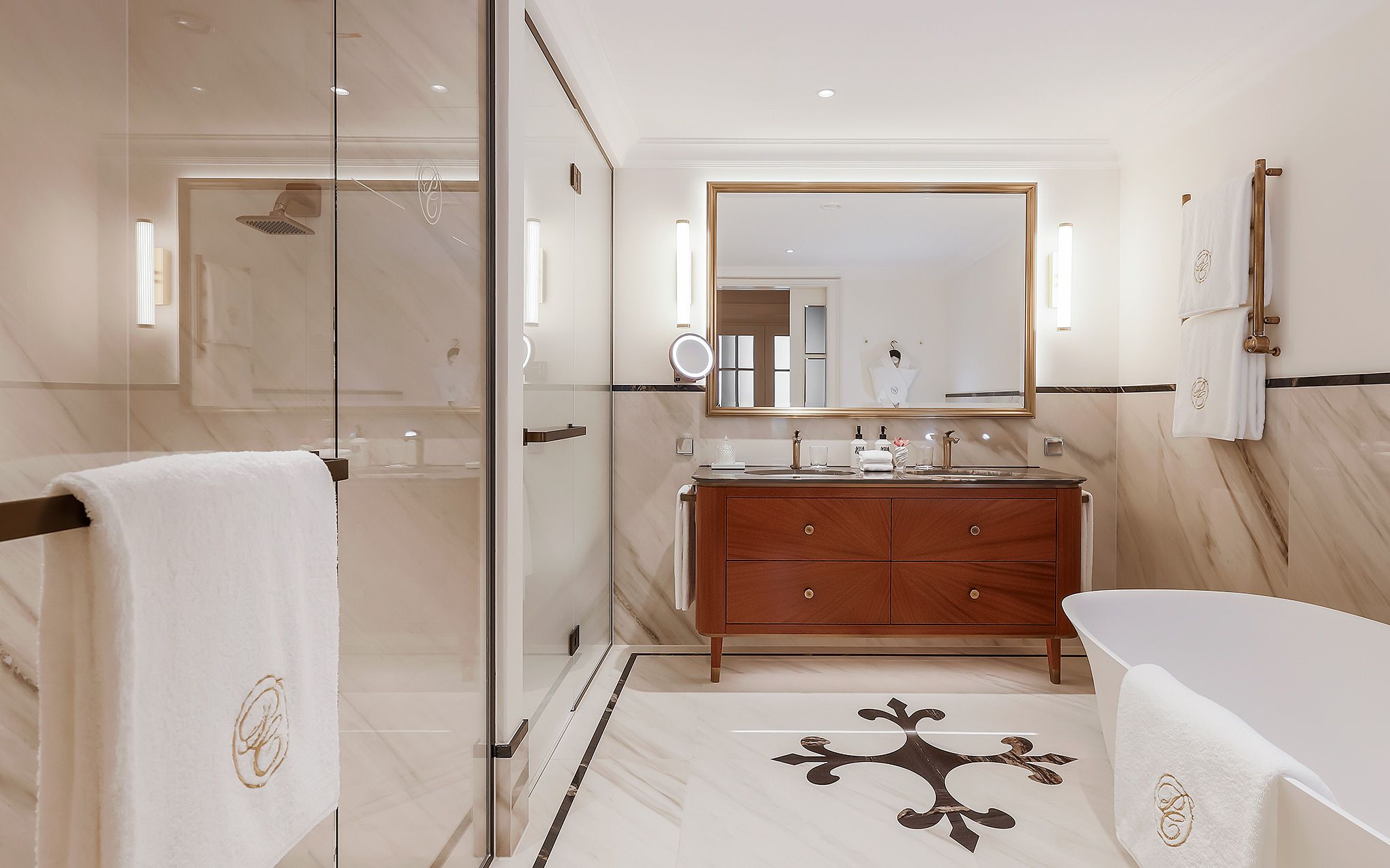 Un baño moderno con cabina de ducha de vidrio, tocador de madera con espejo y bañera blanca.