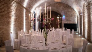 A banquet hall with round tables set for dining, featuring candles and floral arrangements. - Palais Coburg  (Vienna)