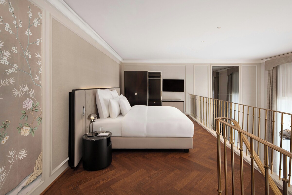 A bedroom with a bed, bedside table, and a TV.
