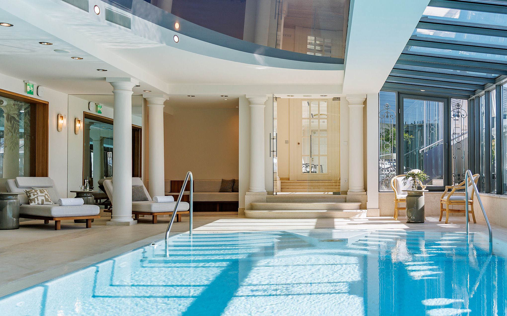 Une piscine intérieure avec des chaises longues et un espace sauna.