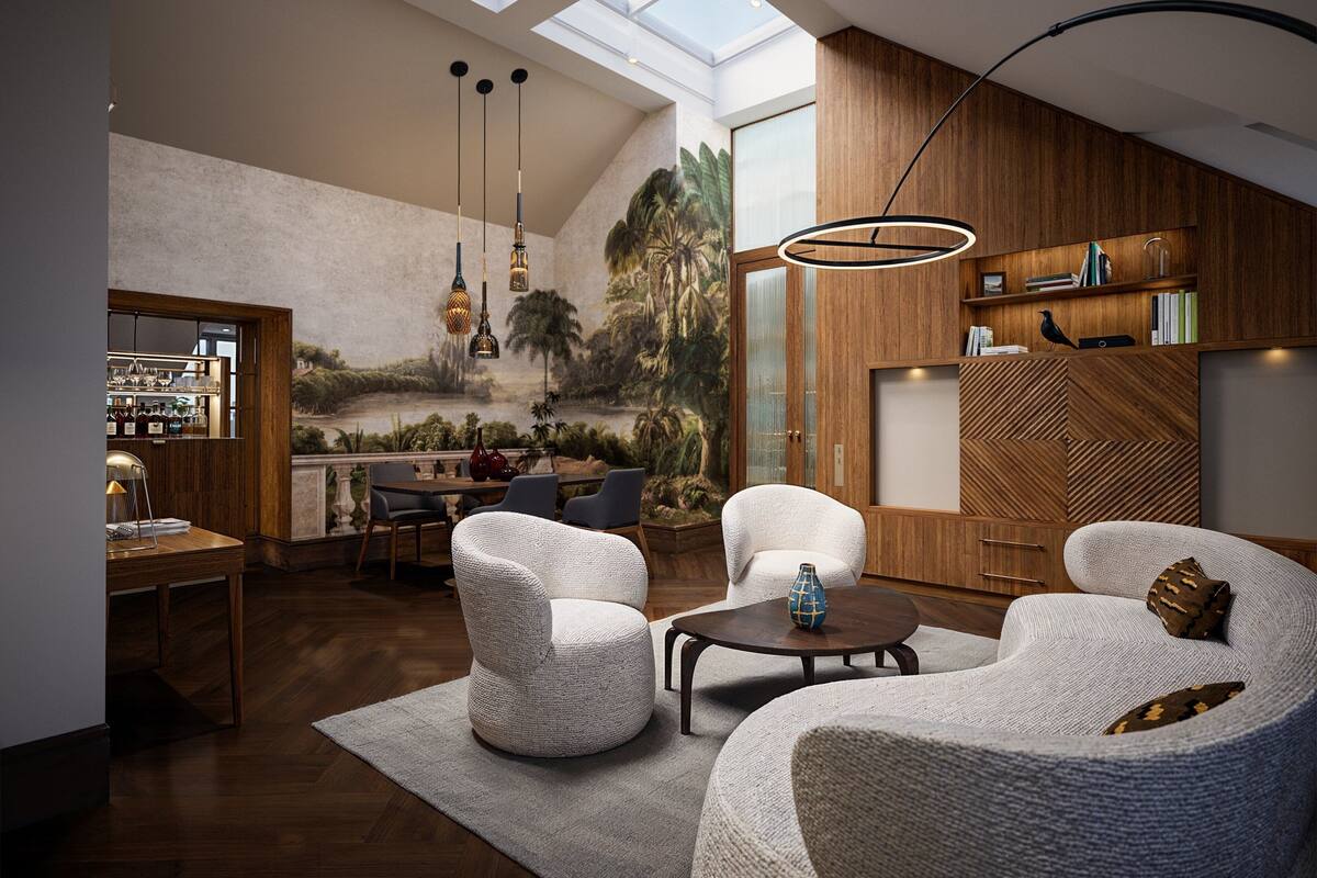 A modern living room with a high ceiling, wooden paneling, and a mural of a tropical landscape. There are two white armchairs, a coffee table, and a dining area with a wooden table and chairs.