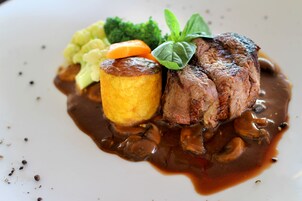 A plated dish with meat, vegetables, and sauce.