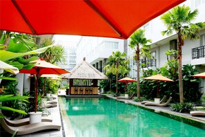 A pool area with lounge chairs, umbrellas, and a pool bar.