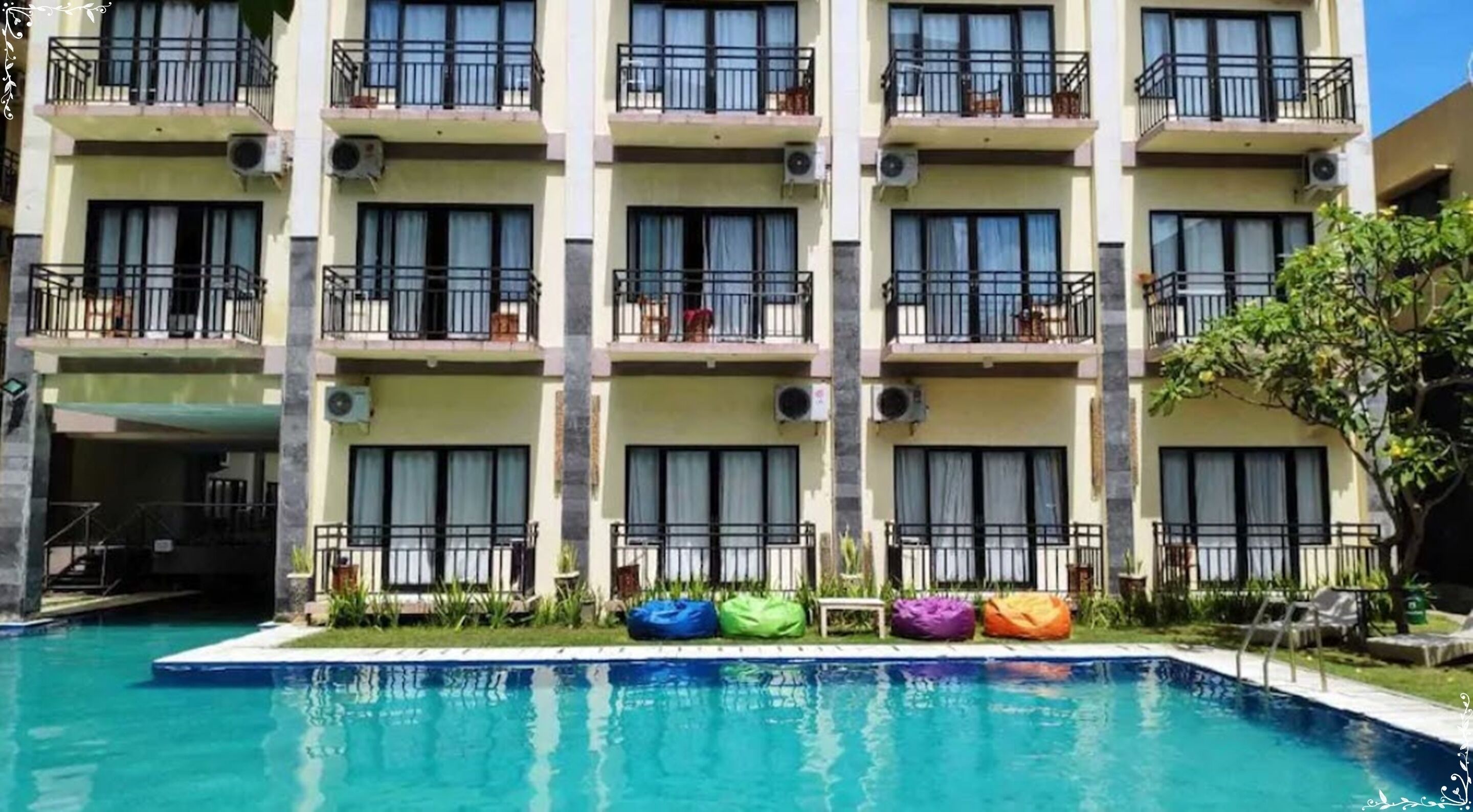 A multi-story hotel with balconies, air conditioning units, and a swimming pool.