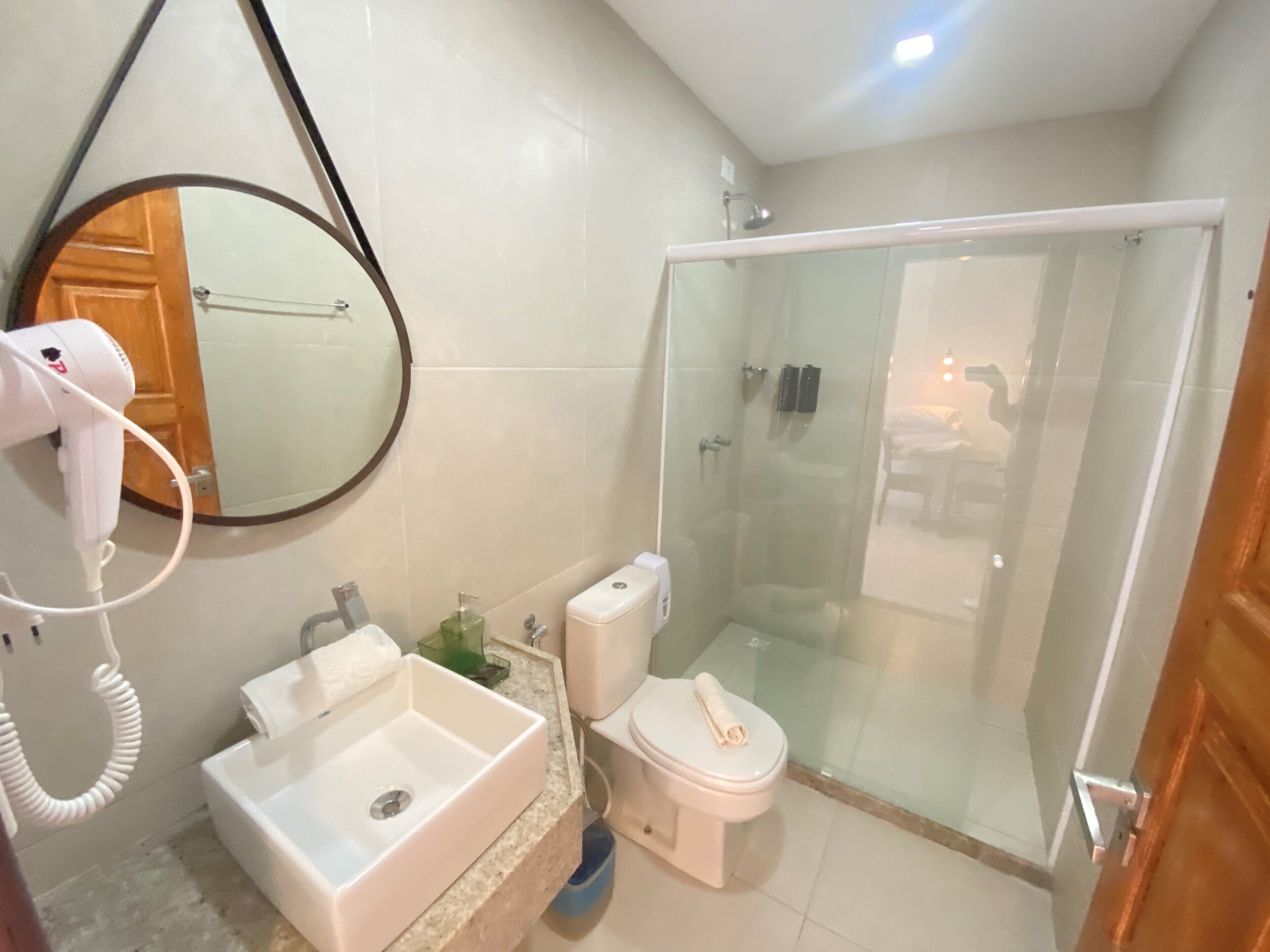 Une salle de bain équipée d’un lavabo, de toilettes et d’une douche à parois de verre.