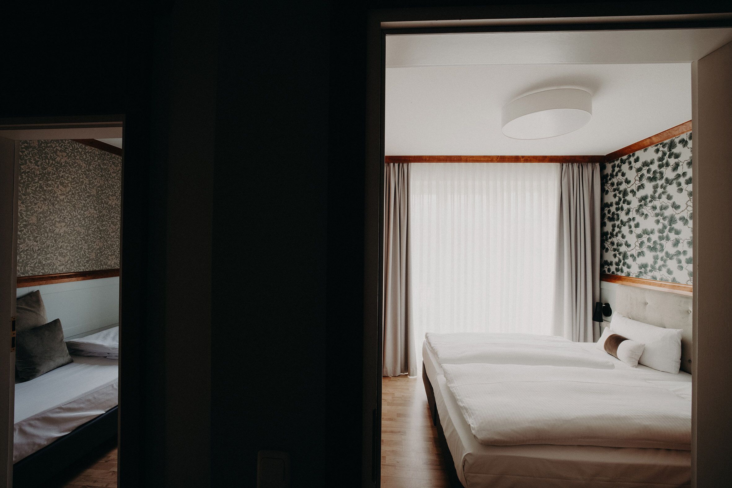 Une chambre d’hôtel avec un lit, une table de chevet et une fenêtre avec des rideaux.