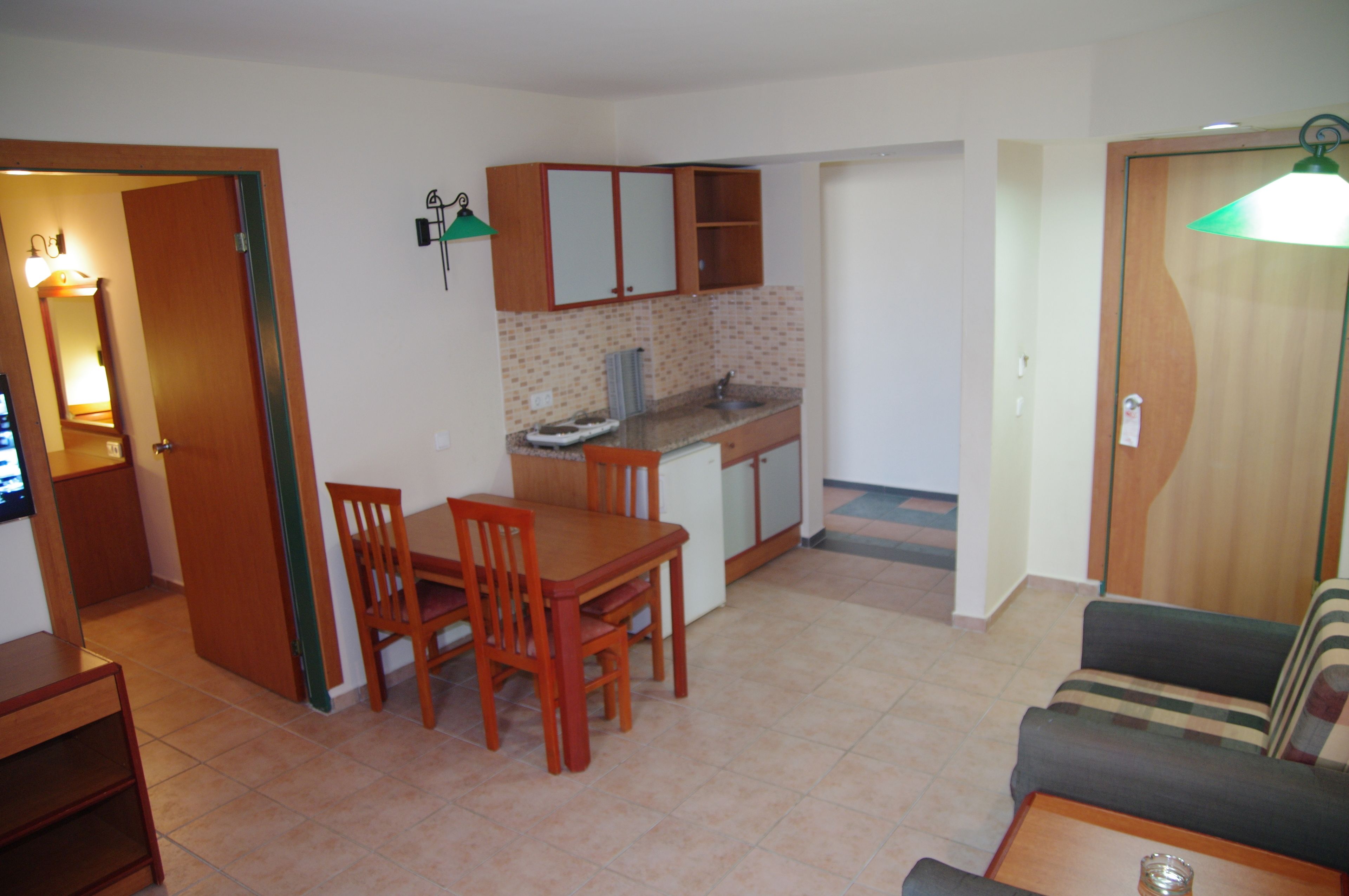 Un espacio habitable compacto con comedor, kitchenette y sofá.