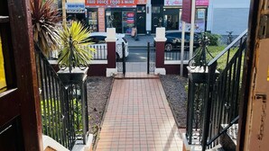 Una escalera que conduce a un edificio con un letrero de 'Fair Price Food & Wine', un letrero de 'New Style' y un salón de belleza 'Soft Beauty'.