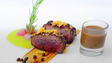 Un plato con un filete, decoración y salsa.