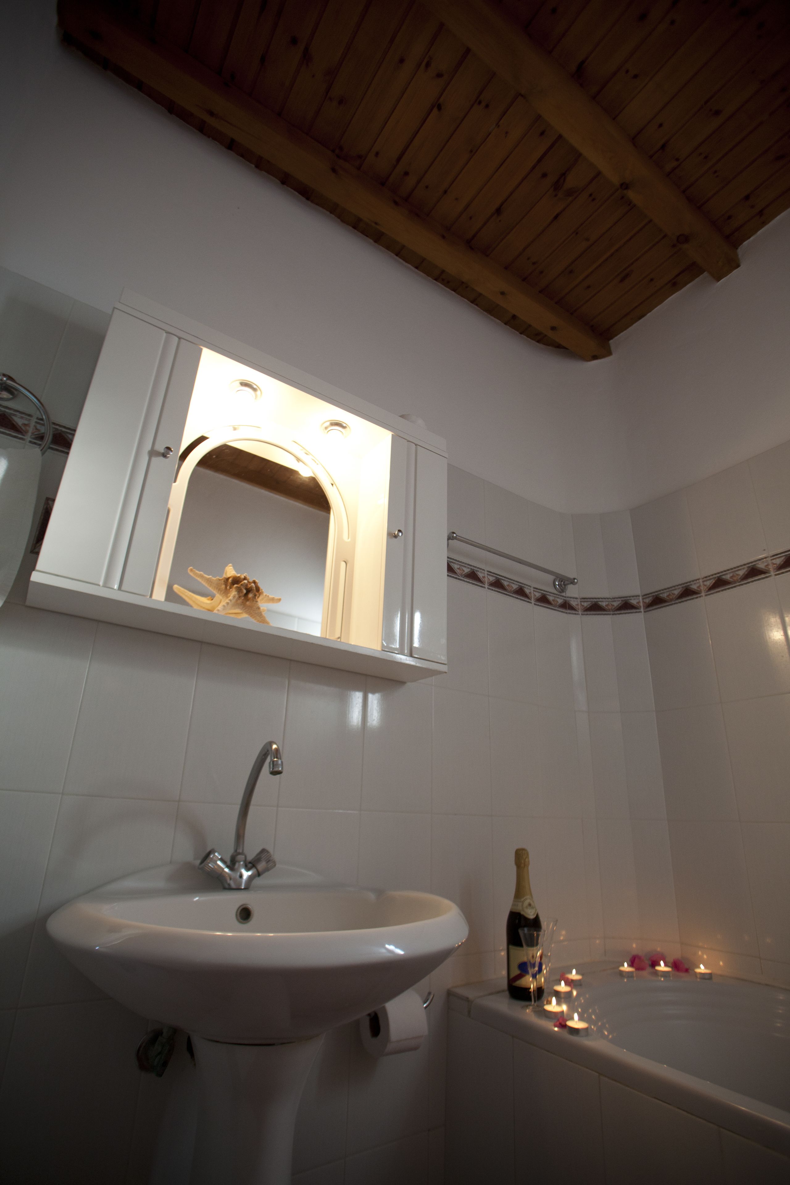 Une salle de bain avec un lavabo, un miroir et une baignoire.