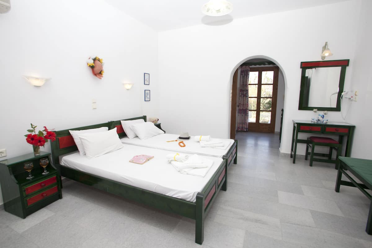 Ein Schlafzimmer mit zwei Betten, einem Schreibtisch und einem Spiegel.