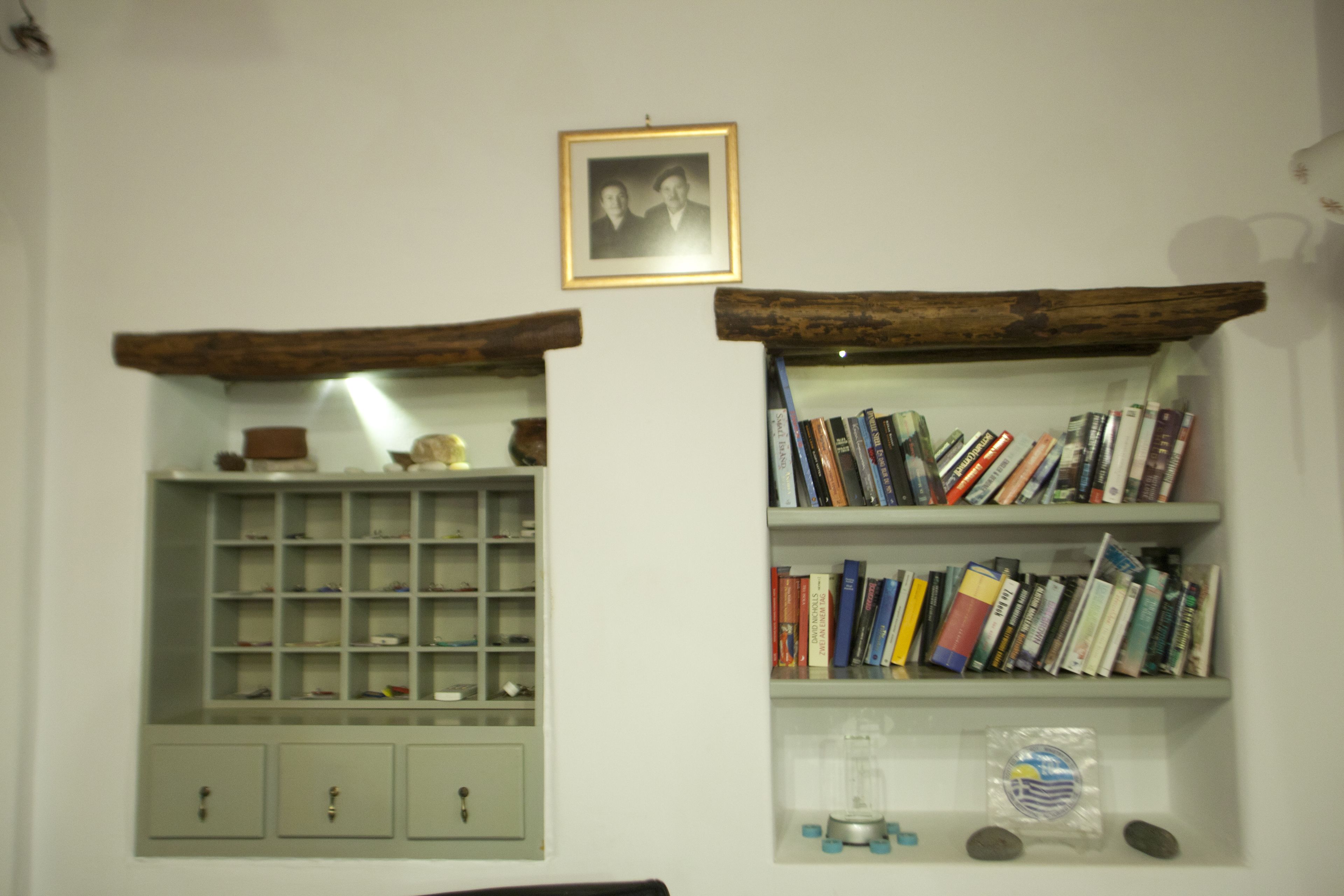 A room with a bookshelf, a framed picture, and a cabinet.