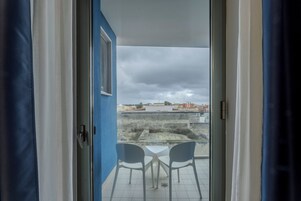 A room with a view of a cityscape through a glass door.
