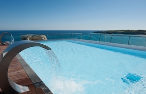 A pool with a clear view of the ocean and a rocky coastline. - Hotel Belvedere, Torre Dell'Orso (Melendugno)