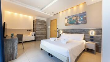 A modern hotel room with a large bed, bedside tables, a desk, and a chair.