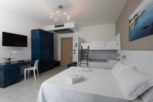 Una habitación de hotel moderna con cama, escritorio, silla y televisor.