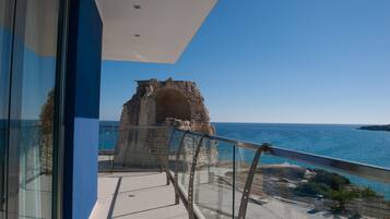 Un balcón con vista despejada al mar y una estructura de piedra.
