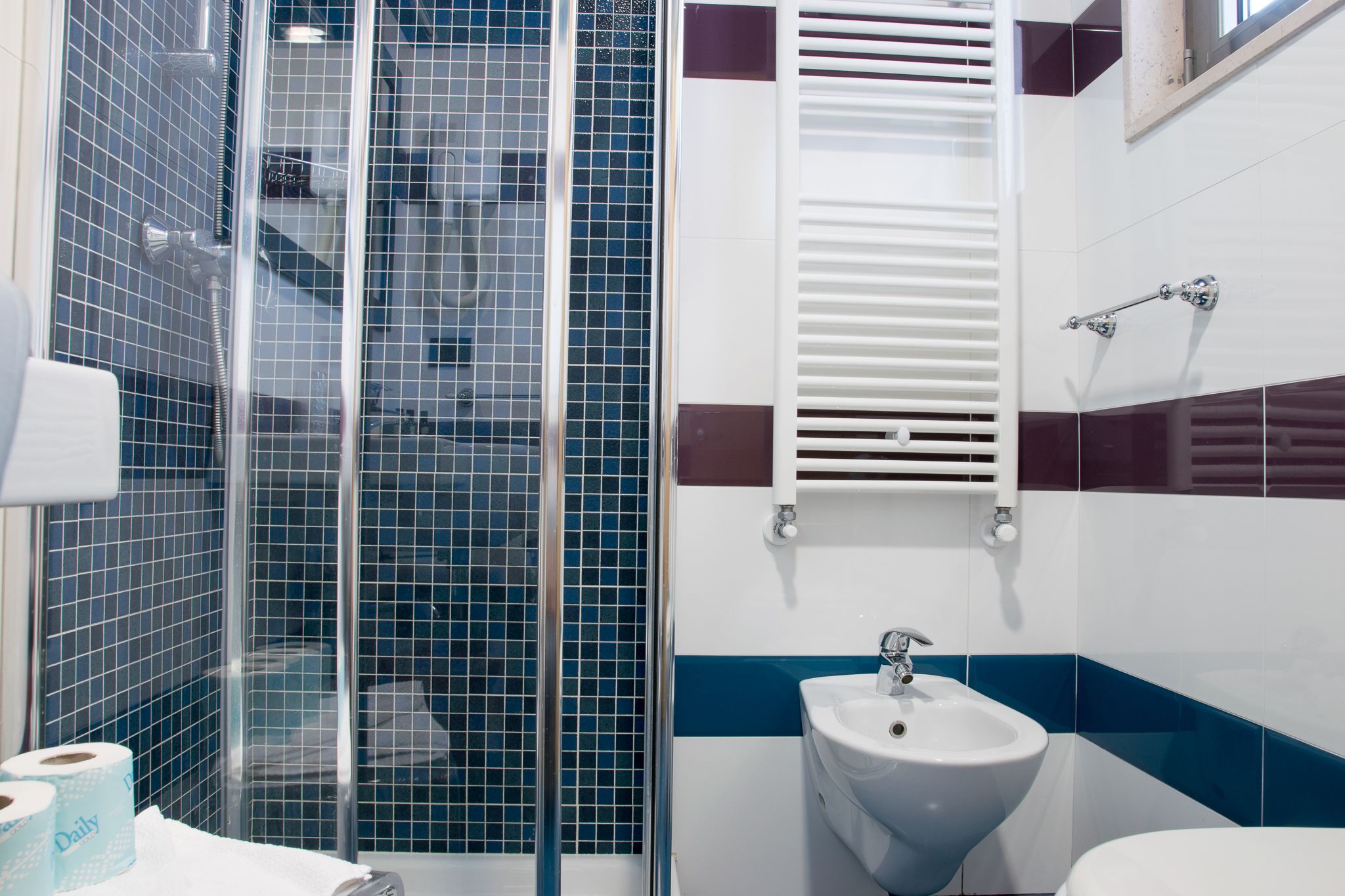 A bathroom with a glass shower enclosure, a sink, and a toilet.