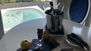 A table with a hot tub, fruits, and a bottle of wine, overlooking a cityscape with red-roofed buildings and hills. - Boutique Hotel Calzavecchio (Casalecchio di Reno)