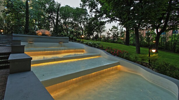 A water feature with illuminated steps in a landscaped garden area. - Boutique Hotel Calzavecchio (Casalecchio di Reno)