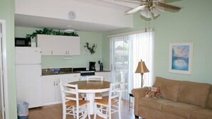 A compact living space with a dining area, kitchenette, and a sofa. - Silver Sands Villas (Fort Myers Beach)