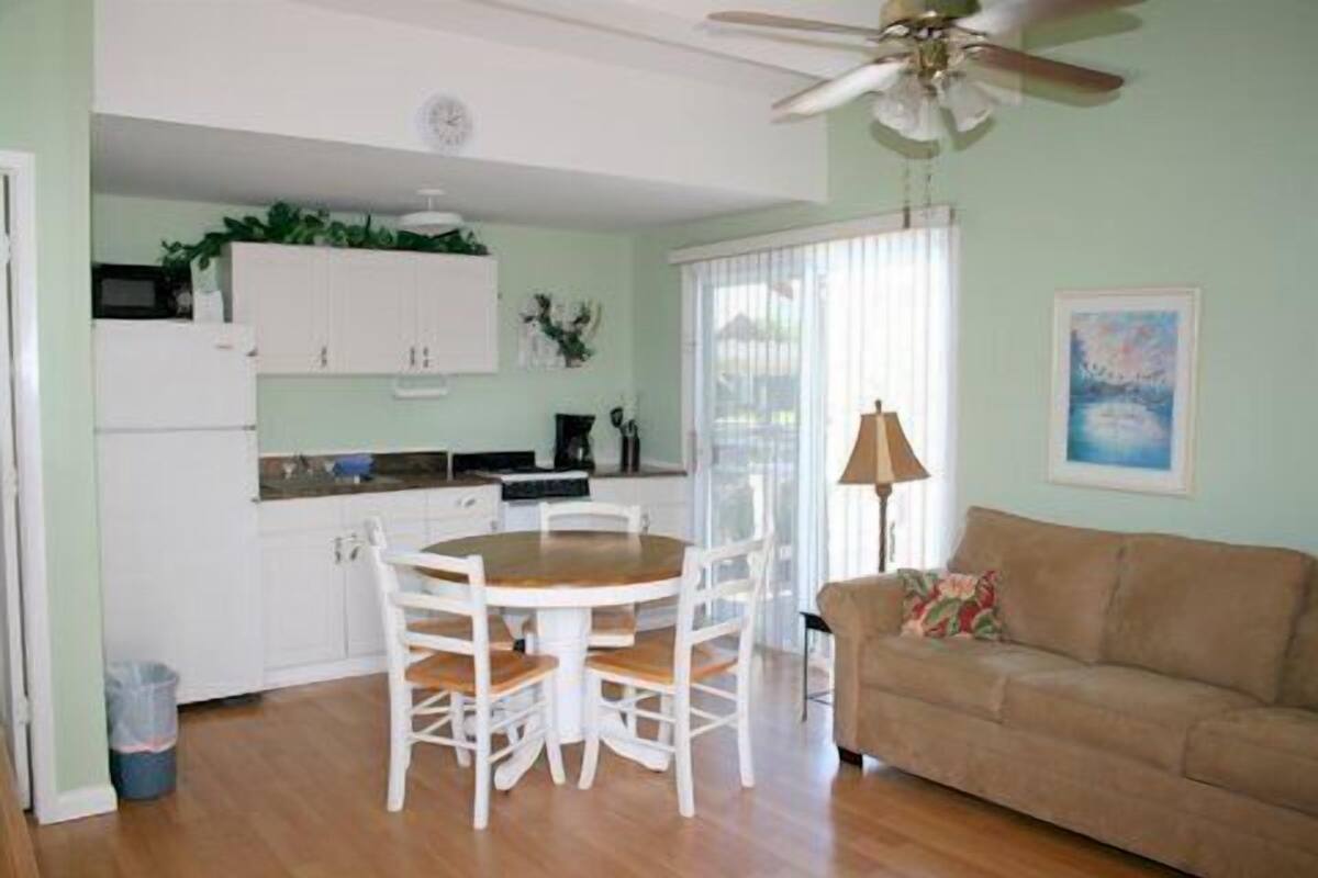 A compact living space with a dining area, kitchenette, and a sofa.