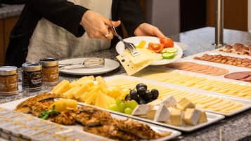 Un bufé con diversos alimentos, incluyendo queso, carnes y frutas.