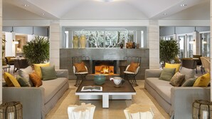 Una sala de estar moderna con chimenea, dos sofás, una mesa de centro y cojines decorativos.