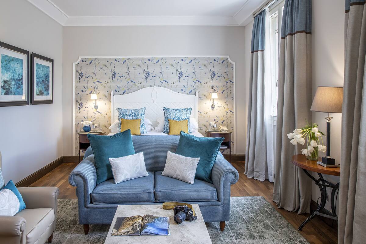 Ein Schlafzimmer mit einem großen Bett, einem Sofa, einem Couchtisch und einem Nachttisch mit Lampen.