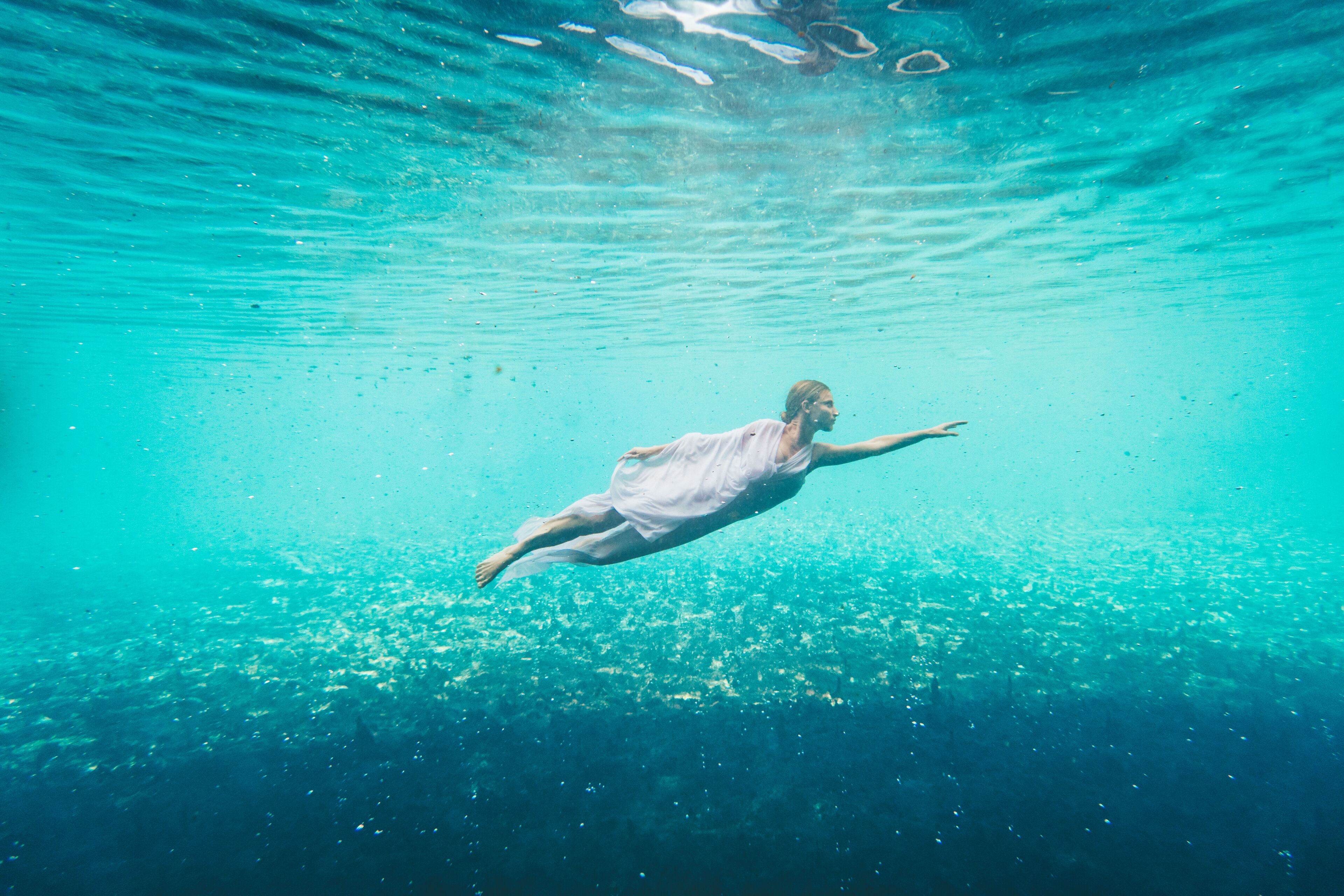 Una persona che nuota sott'acqua.