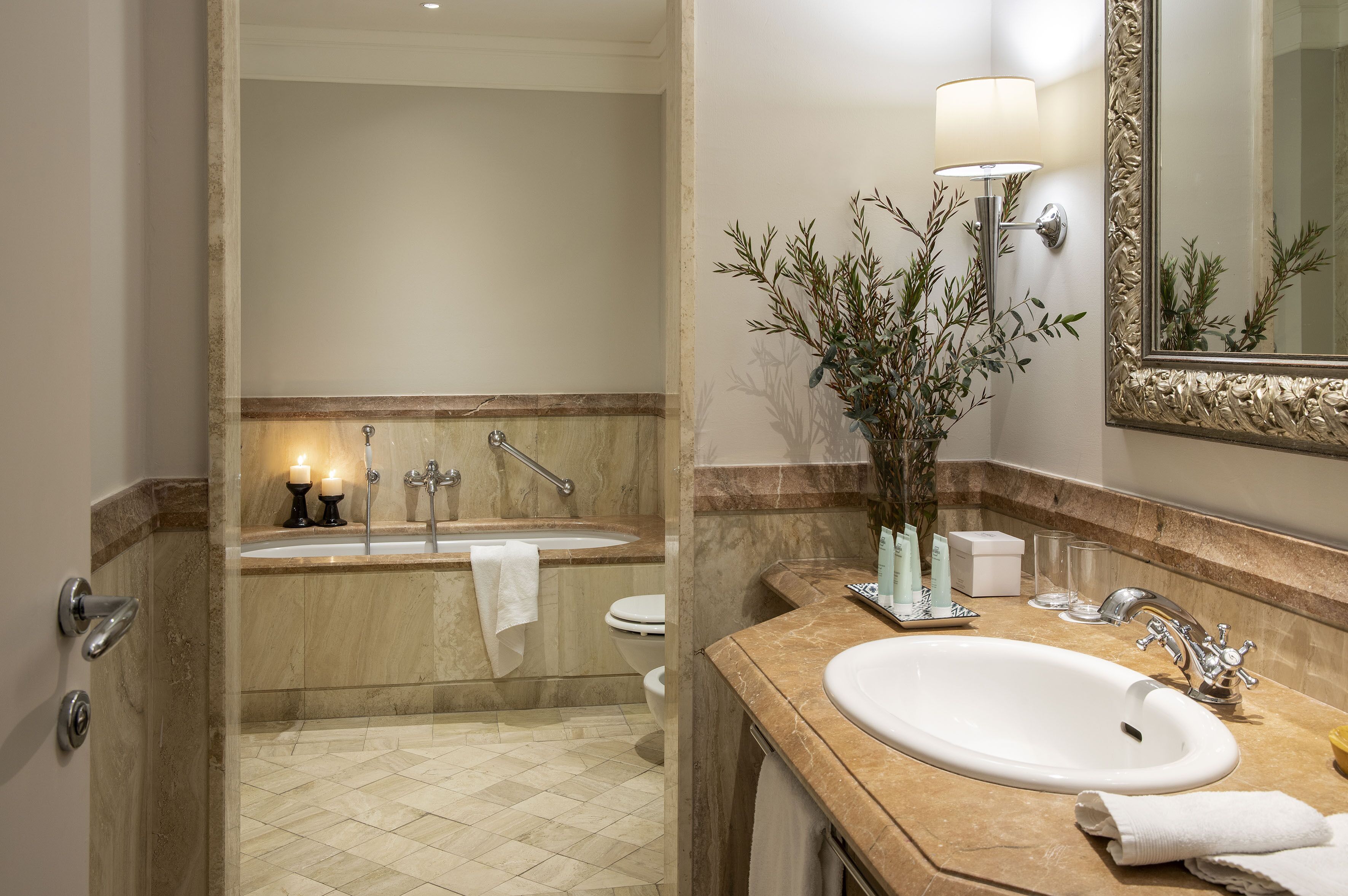 A bathroom with a sink, mirror, and a bathtub.