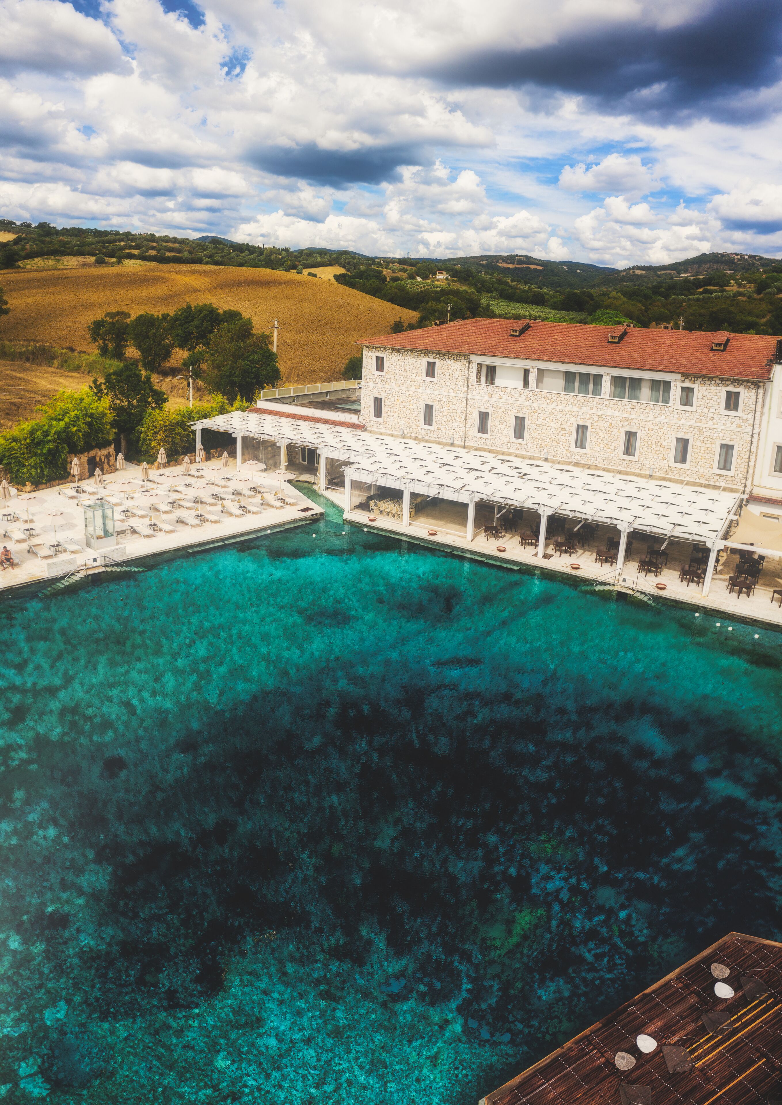 Um edifício grande com piscina e área de estar externa.