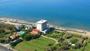 An aerial view of a coastal hotel with a large building, a swimming pool, and a beach area. - Riviera Spineta (Battipaglia)