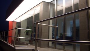 A modern building with large glass windows and a metal railing. - Riviera Spineta (Battipaglia)