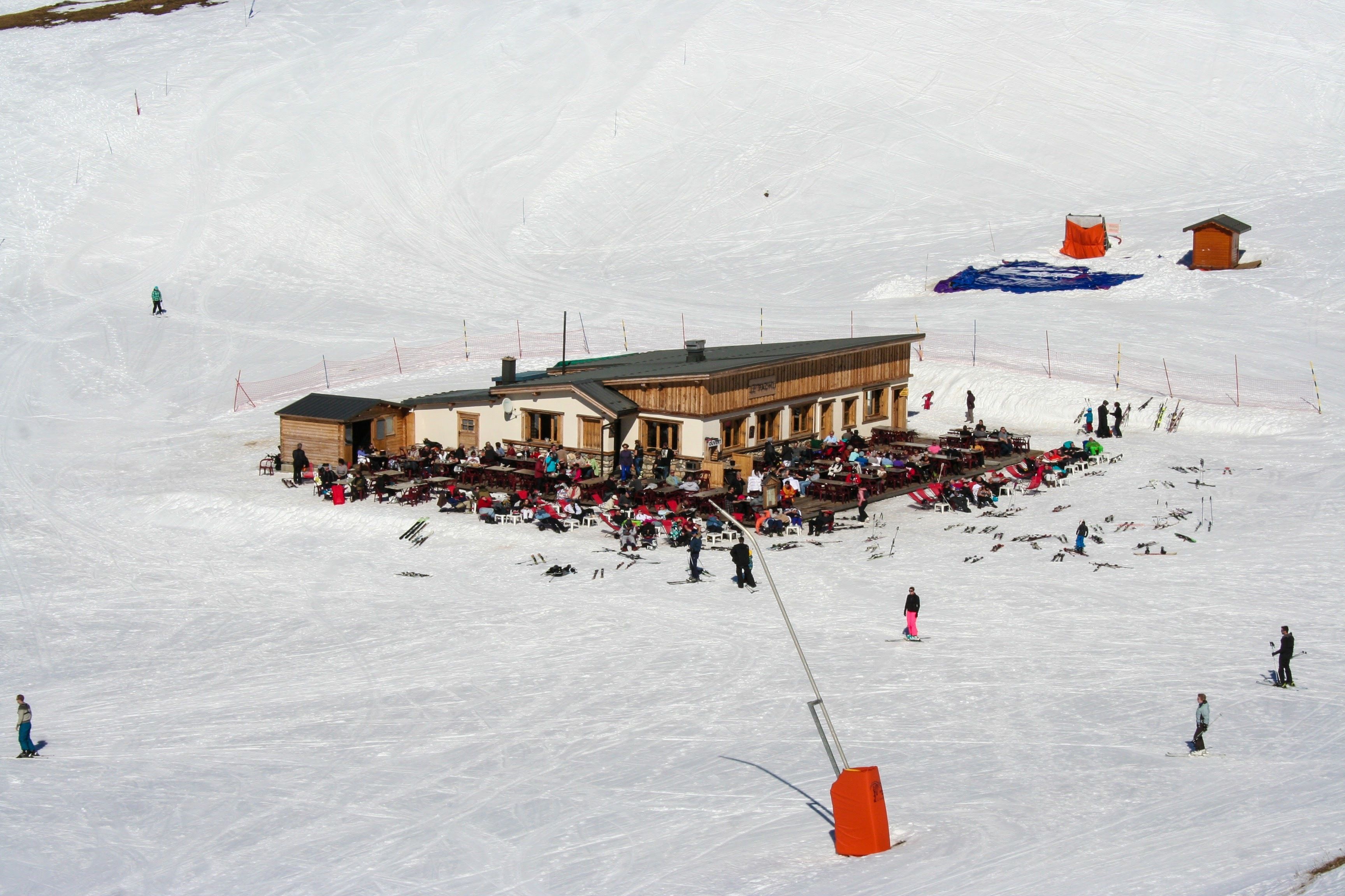 Une station de ski dotée d’un chalet, de pistes de ski et d’un télésiège.