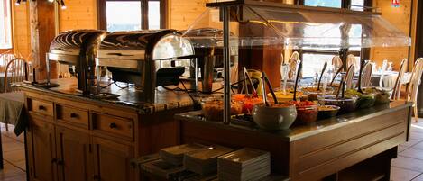 A buffet setup with a variety of food items and a coffee machine.