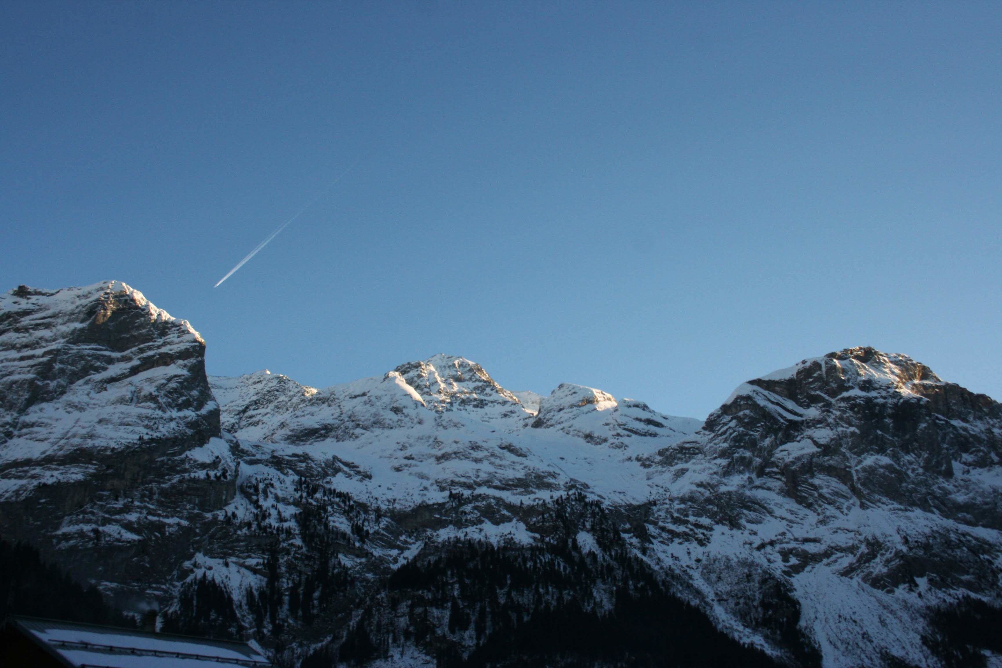 A mountain range with snow-covered peaks and a clear sky.